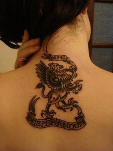 tatuaje en la nuca de símbolo de Grifón con lema en la cinta