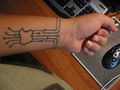 Apple logo on digital board arm tattoo