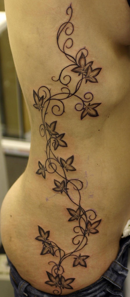 Girls rib tattoo, long plant with interesting leaves