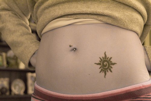 Girl stomach tattoo, black, designed, waving sun