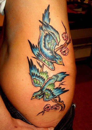 Le tatouage élégant des oiseaux bleus sur la branche