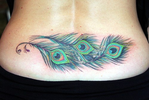tatuaje en el bajo de la espalda de plumas de pavo real