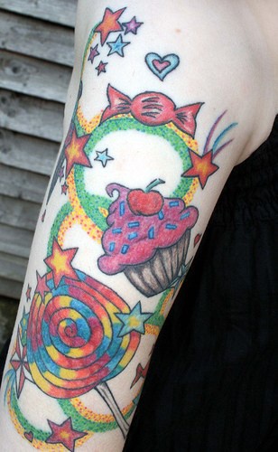 tatuaje colorido de caramelos,magdalenas y estrellas