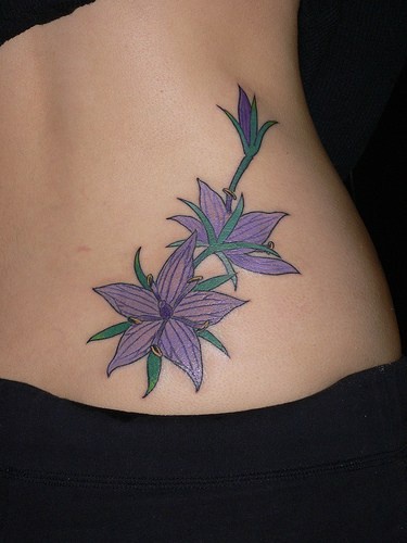 Tre fiori viola tatuagio sula fianco