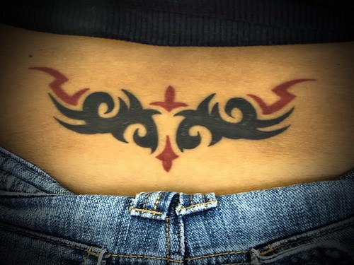 Le tatouage d&quotentrelacs rouge et noir sur le bas du dos