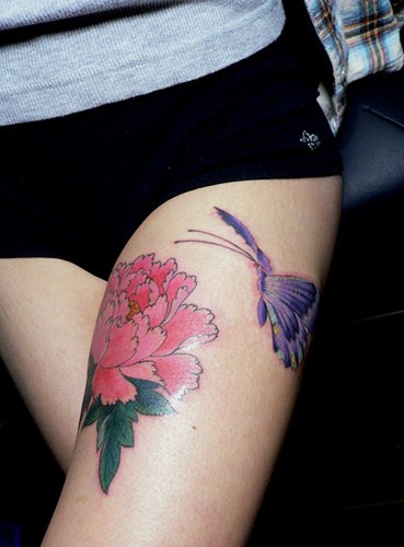tatuaje en la cadera de mariposa morada y flor rosa
