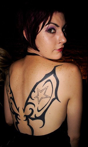 tatuaje en la espalda femenina de tribal de alas de mariposa