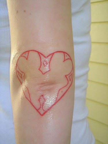 tatuaje en el codo de la lina roja de corazón