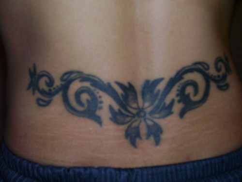 tatuaje en el bajo de la espalda de la tracería de flor