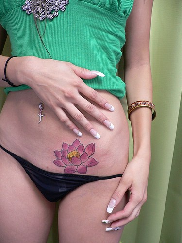 Fiore rosato tatuaggio sulla pancia abbasso
