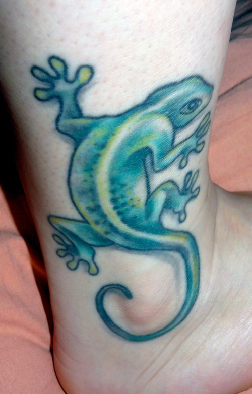 Pale green lizard tattoo on ankle