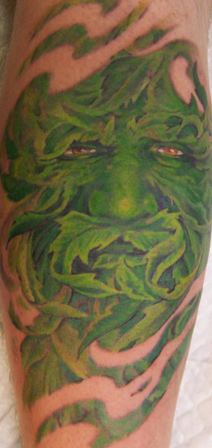 Tatuaje en la pierna,  hombre de las hojas verdes con ojos rojos