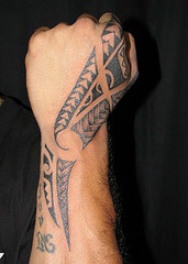 Tatuaggio nero in stile tribale tatuato sulla mano e il braccio