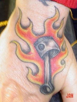 Tatuaje en la mano, herramienta y fuego