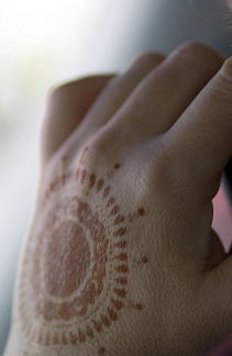 Tatuaje en la mano, estilo indio, círculo como sol, marrón