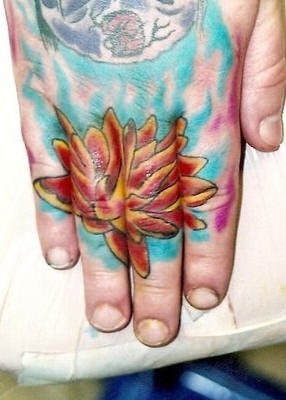Tattoo von roter fantastischer Pflanze an der Hand