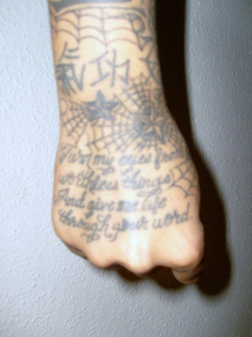 Tatuaggio su tutta mano : la ragnatela , la scritta, le stelle e i geroglifici