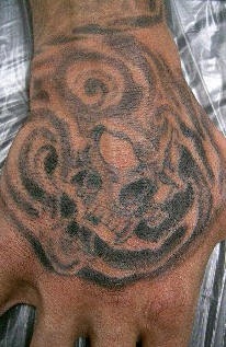 Tatuaje en la mano, monstruo en el humo