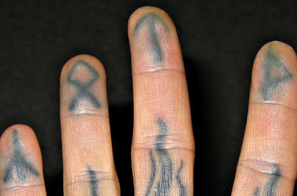Tattoo von kleinen verschiedenartigen Zeichen und Symbolen an Fingern