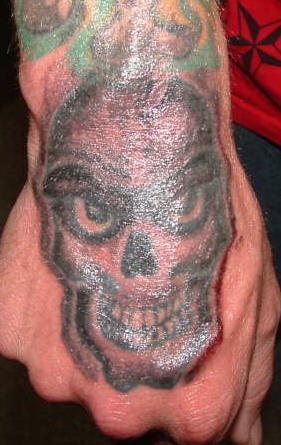 Tatuaje en la mano, monstruo con ojos malvados