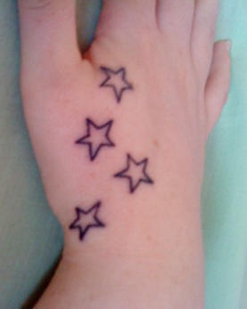 Tatuaje en la mano, cuatro estrellas similares, simples