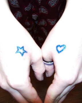 Piccola stella e piccolo cuore tatuati sulle mani