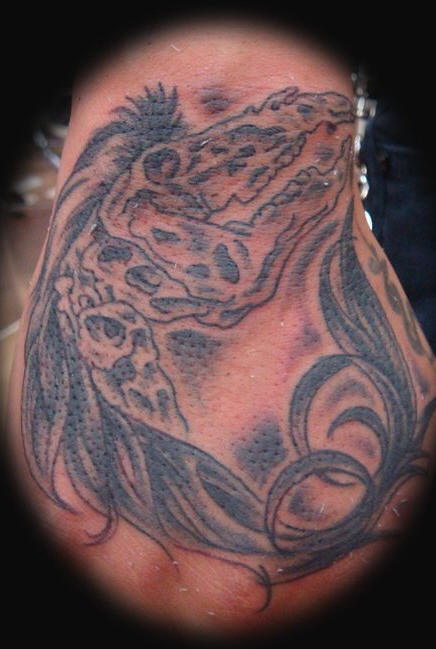 Tatuaje en la mano, esqueleto de un monstruo horroroso con el pelo largo