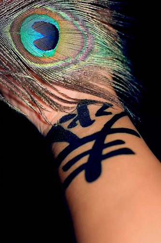 Bold, black, saturated wide hieroglyph hand tattoo