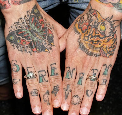 Tattoo von Schmetterling und Tiger an Händen und Inschrift an Fingern