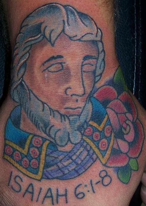 Tattoo von stilisiertem Mann mit geschlossenen Augen und Inschrift  Isaiah 6:1-8 an der Hand