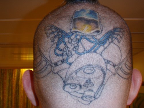 Head tattoo, yellow and blue flying apparatus