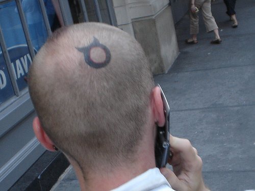 Kopf Tattoo, runde Schild mit Hörnern wie Teufel