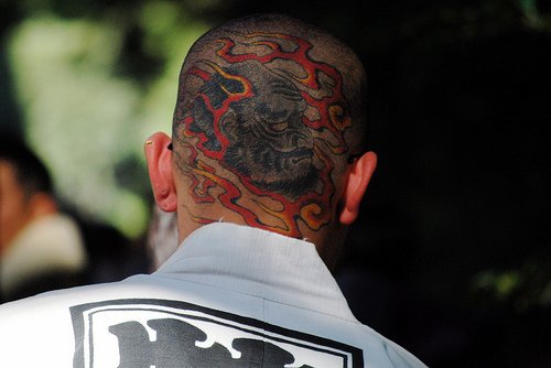 Head tattoo with bearded,wrinkled monster, in fire