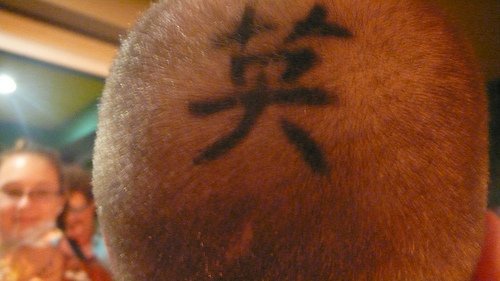 Head tattoo with big, black hieroglyph