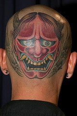 Tatuaje en la cabeza, monstruo loco con la cara roja, con colmillos