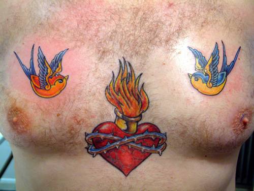 Cuore in fiamma e passeri tatuaggio sul petto