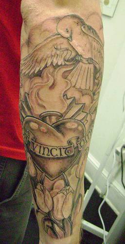 tatuaje de corazón en llamas con paloma blanca