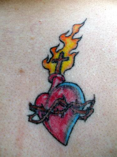 tatuaje de corazón en llamas con cruz