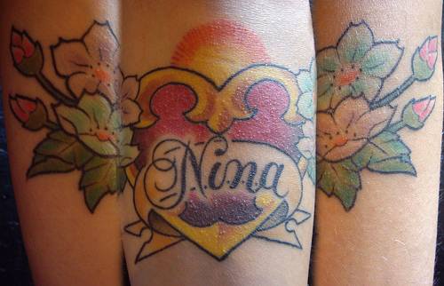 tatuaje de corazón dorado con flores