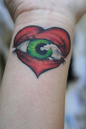 tatuaje en la muñeca de corazón con ojo verde