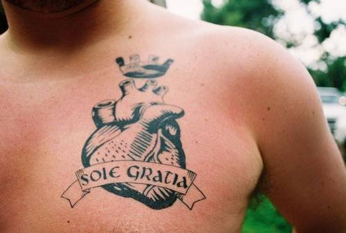 tatuaje de escritos latinos con corazón real con corona