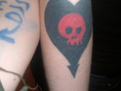 Schwarzes Herz mit rotem Schädel Tattoo