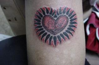 Red heart in black shining tattoo