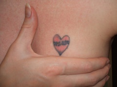 tatuaje en el pecho de corazón pequeño rojo