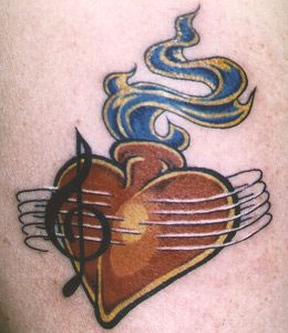Le tatouage de cœur musical en flammes
