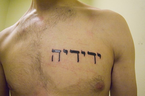 Le tatouage des écrits en hébreu sur la poitrine