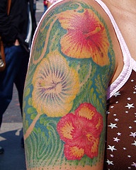 Hibiscus flowers on green background shoulder tattoo