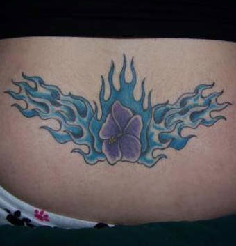 tatuaje de en el bajo de la espalda de flor morada en tracería de llamas azules