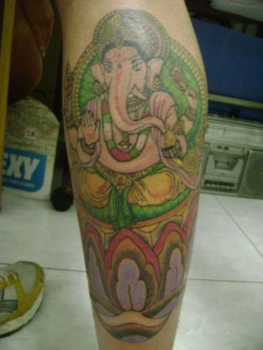 tatuaje en la pierna de Ganesha en oro