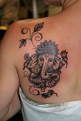 tatuaje en l espalda de Ganesha con flores